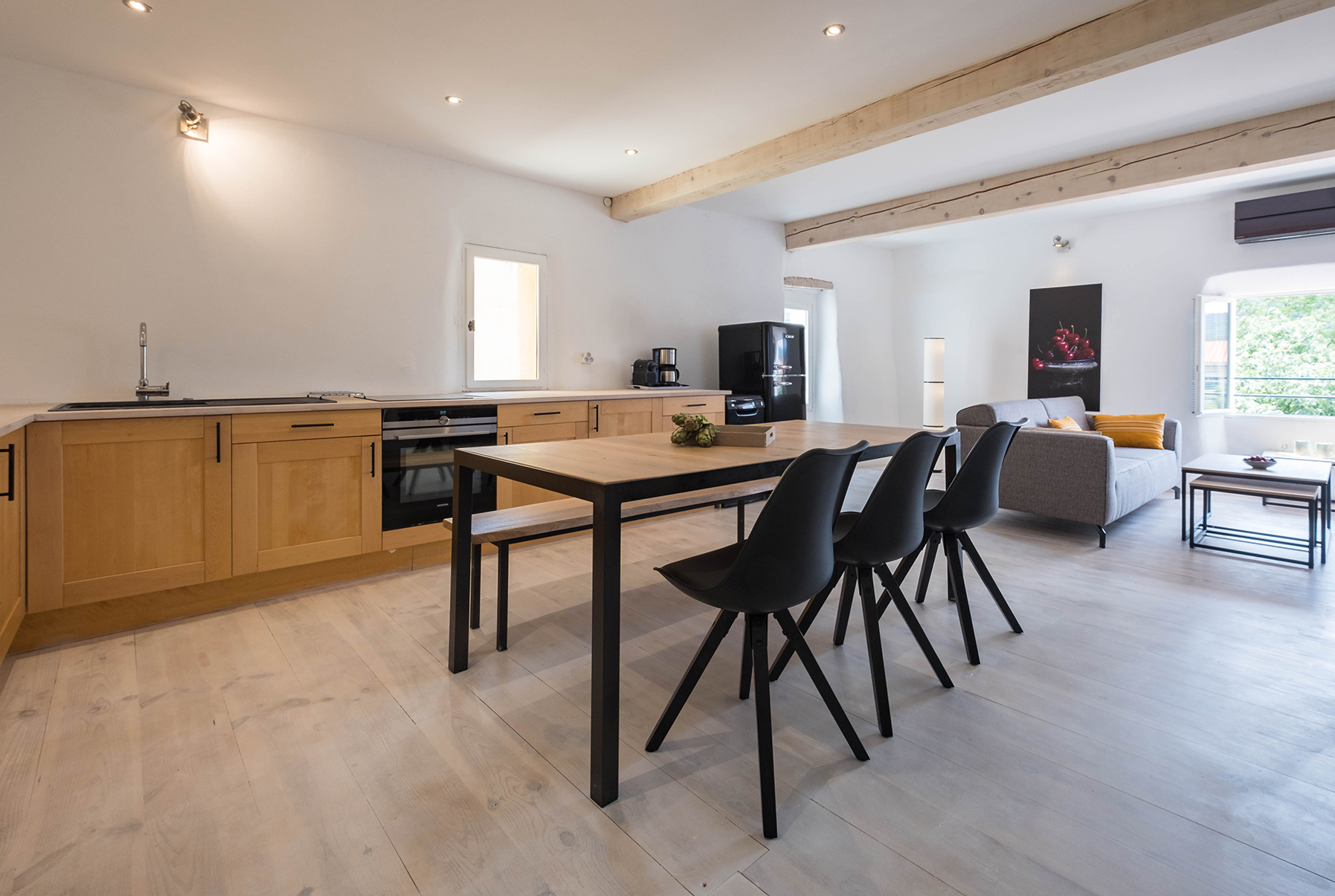 Keuken, eettafel en woonkamer van Duplex 77 onder houten balken