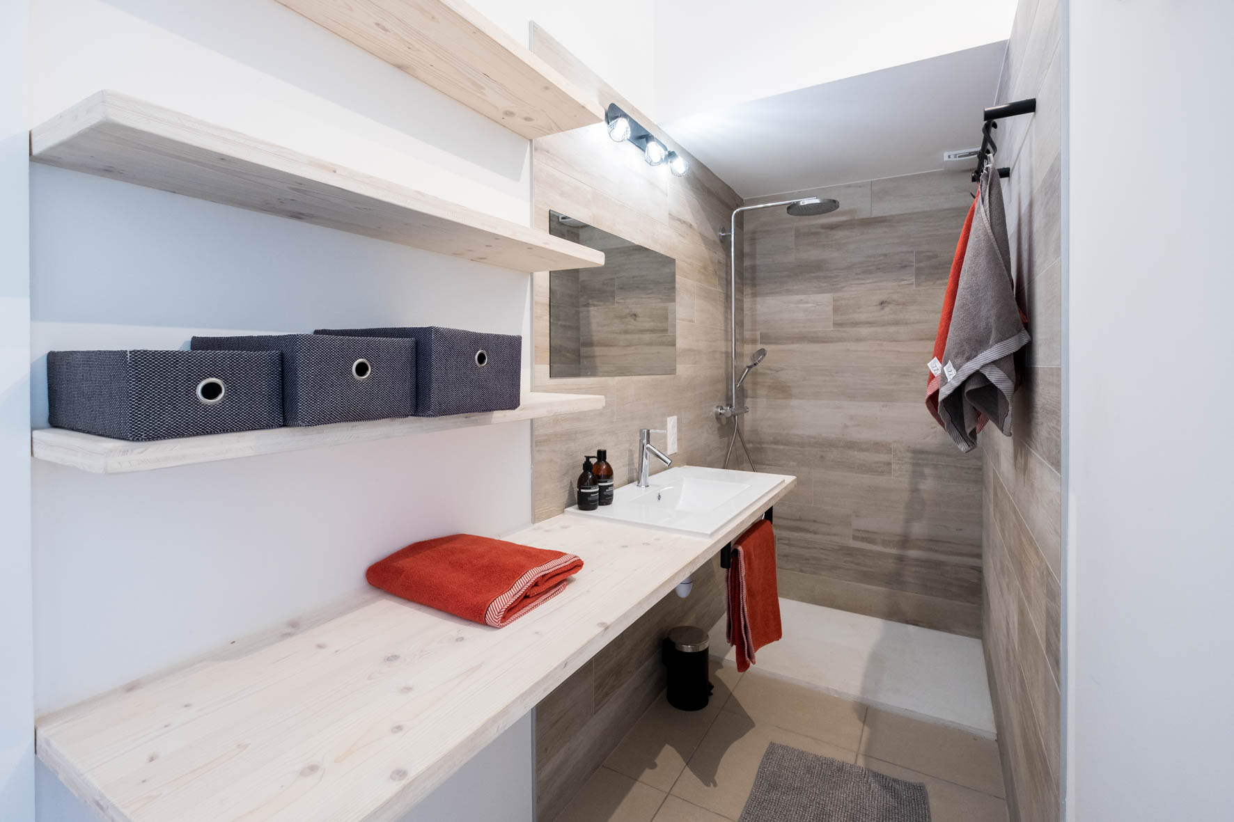 Doucheruimte van Duplex 77 met wastafel en planken