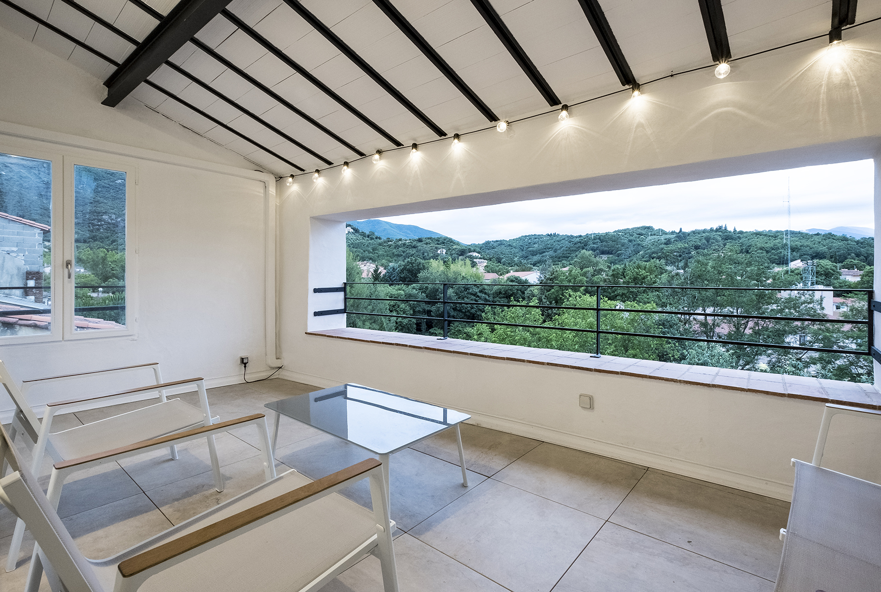 Lounge van Duplex 77 met een panoramaraam op de heuvels